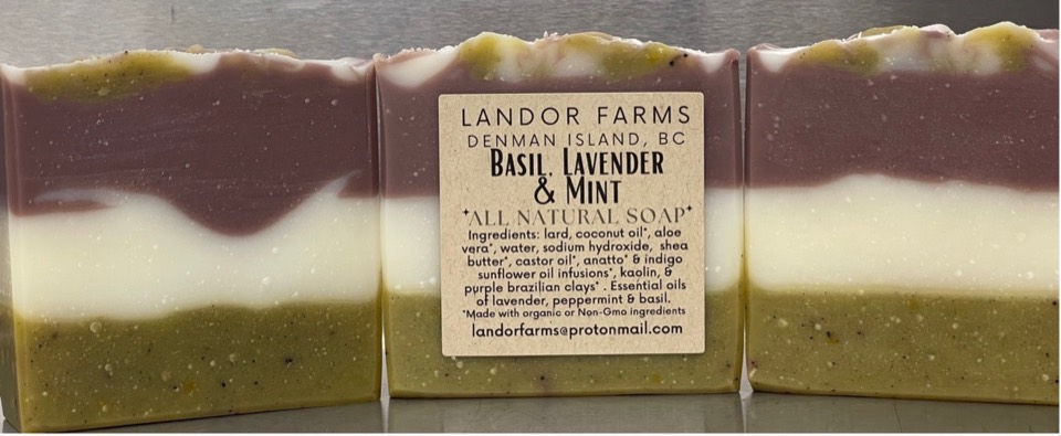 Three Basil Lavender Mint soap bars in plum, cream and olive green layers; the middle bar has a Landor Farms label