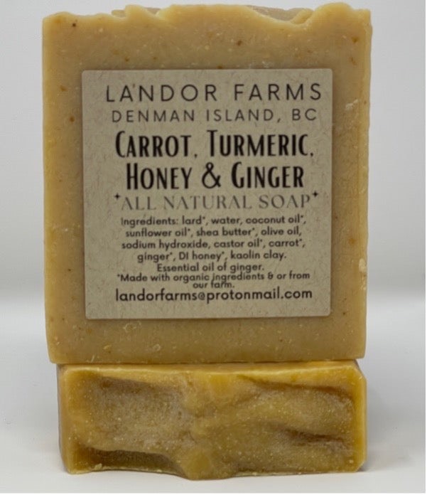Carrot Turmeric Honey & Ginger soap bar in pale golden yellow with a Landor Farms label, standing on a second bar