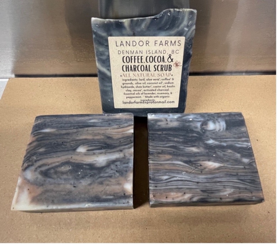 Three Coffee, Cocoa, & Charcoal bars in grey, tan and white swirls, one standing with a Landor Farms label