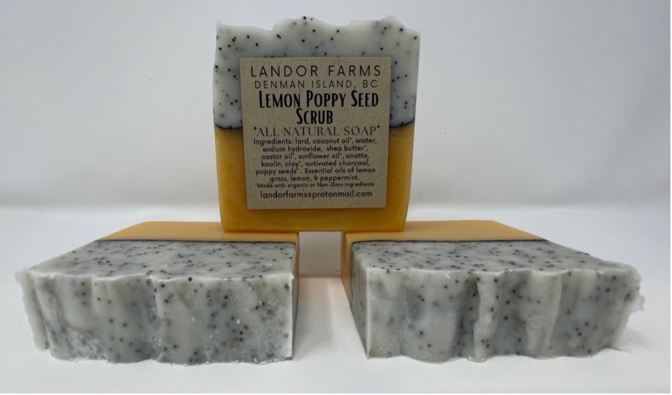 Lemon Poppy Seed soap: a labelled bar with a speckled white top and yellow base behind two more bars, on white